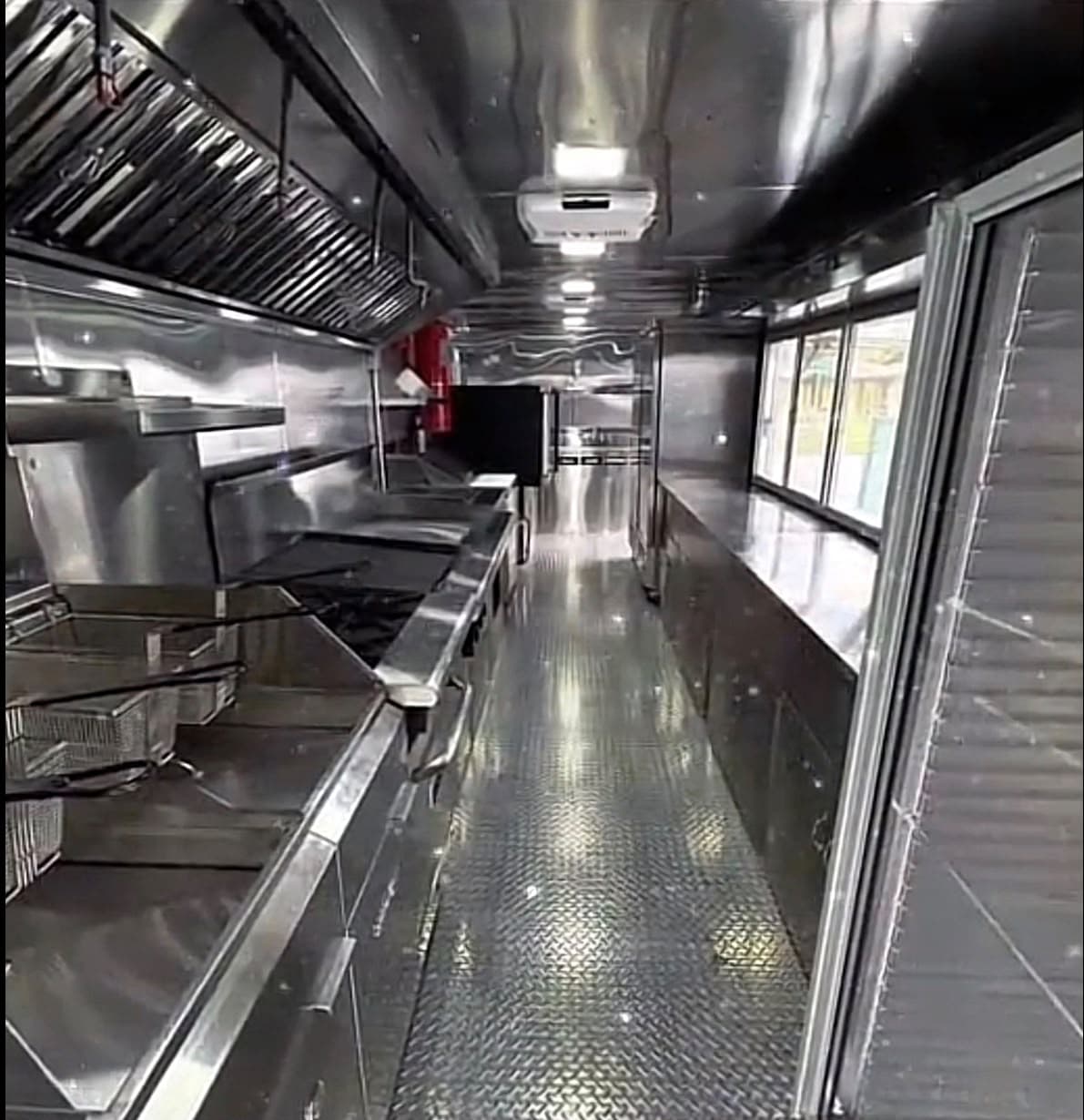 Vista 8 del interior del food truck con equipo de cocina y superficies de acero inoxidable.